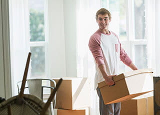 A college student carries boxes out of his home