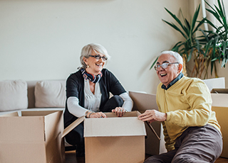 Happy older couple packs boxes in their home