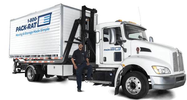 A 1-800-PACK-RAT driver stands next to his mini-mover truck with a portable storage container sitting on the back of it