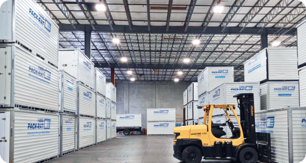 A view of 1-800-PACK-RAT containers and a forklift in a 1-800-PACK-RAT storage facility