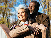 A happy retired couple looks on in the sunshine