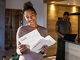 A woman checks her mail in her home