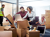 A group of employees and a labor provider pack and move boxes out of their office area