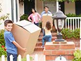 A kid moving a box into his new home with his family.