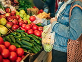 A woman picks produce at a store