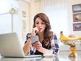 A woman anxiously reads on her phone